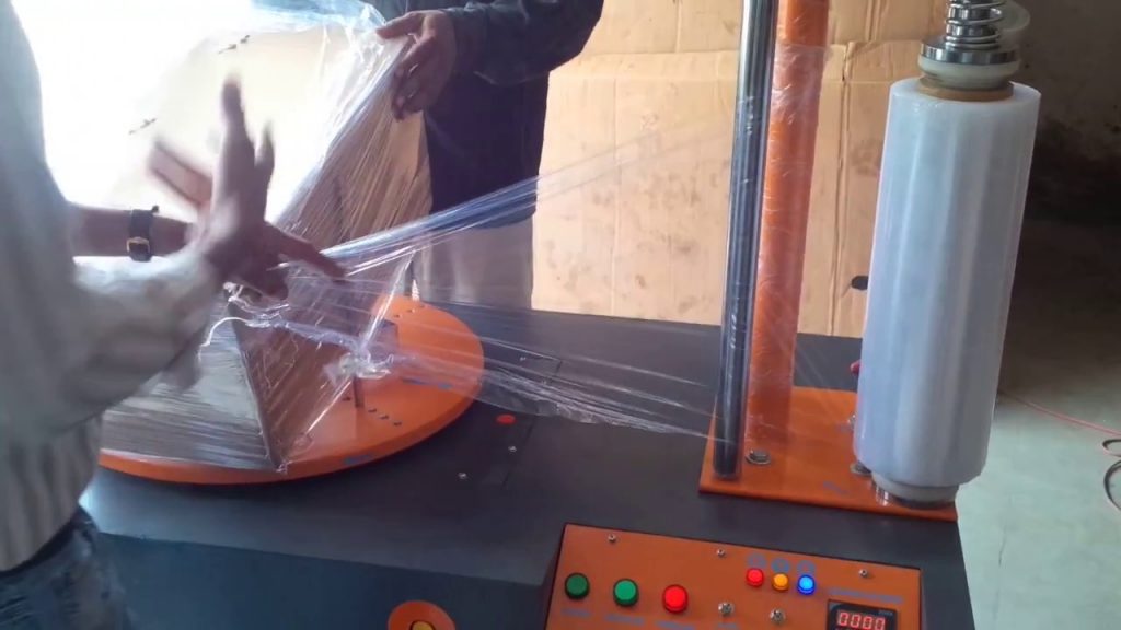 Compact machine for wrapping boxes.